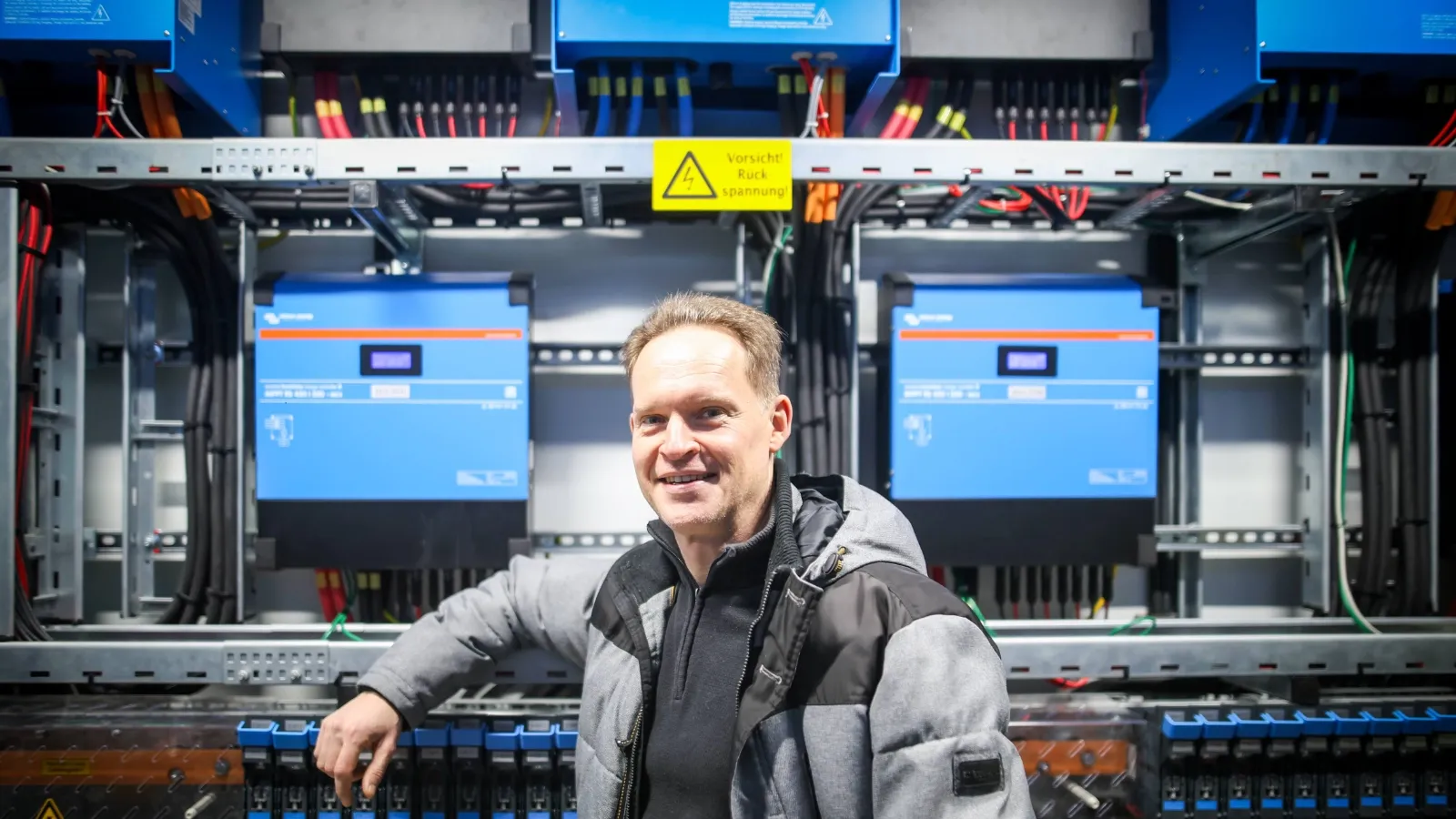 Oliver Kügow vor einem Batteriespeicher-Schrank